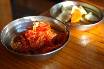 Cabbage kimchi is provided on stainless steel plate.