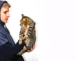 adolescente mirando a su gato y llevándolo en sus brazos