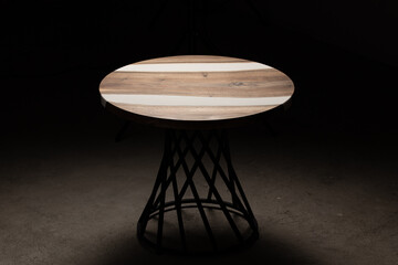 Expensive vintage furniture. The table is covered with epoxy resin and varnished. Luxury quality wood processing. Wooden table on a dark background. Business proposal concept.