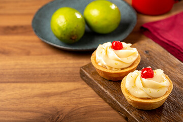 Lemon tartlets decorated with cherry.