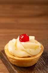 Lemon tartlets decorated with cherry.
