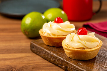 Lemon tartlets decorated with cherry.