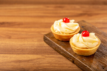 Lemon tartlets decorated with cherry.