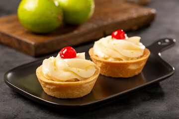 Lemon tartlets decorated with cherry.