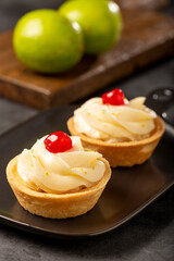 Lemon tartlets decorated with cherry.
