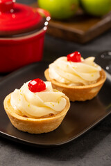 Lemon tartlets decorated with cherry.