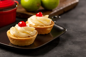 Lemon tartlets decorated with cherry.