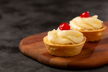 Lemon tartlets decorated with cherry.