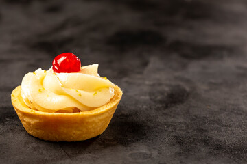 Lemon tartlets decorated with cherry.