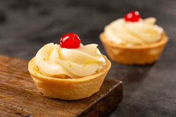 Lemon tartlets decorated with cherry.