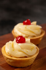 Lemon tartlets decorated with cherry.