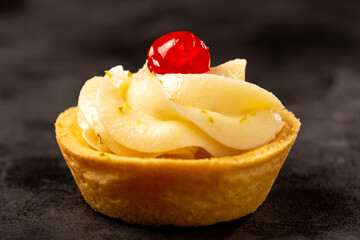 Lemon tartlets decorated with cherry.