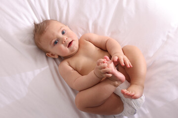 Cute little baby lying on bed, top view