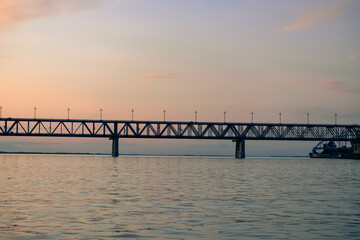 Fototapeta na wymiar Bridge over the Amur river at sunset. Russia. Khabarovsk. Photo from the middle of the river.