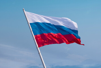 Russian flag waving in the wind over blue sky