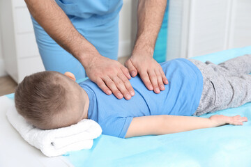 Obraz na płótnie Canvas Orthopedist massaging child's back in clinic, closeup. Scoliosis treatment