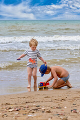 Two little boys are playing on the seashore - 490828827