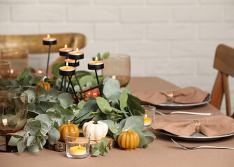 Autumn table setting with eucalyptus branches and pumpkins indoors