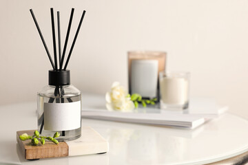 Aromatic reed air freshener on white table, space for text