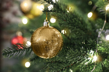 Beautifully decorated Christmas tree with golden bauble, closeup