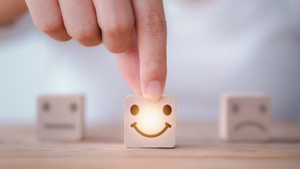 Customer service satisfaction survey concept. Customer hand choose happy smiley face, blurred...