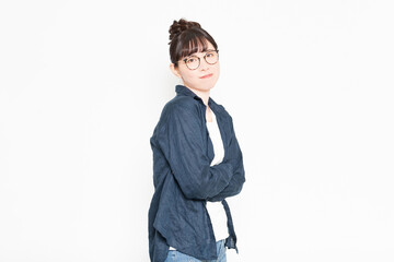 白い背景の前に立って腕組みしている眼鏡をかけている女性