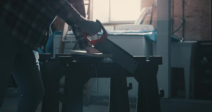 Push in on saw blade as a man cuts wood