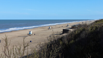 Beach scene in winter, with blue sky and calm sea, Carilo, Argentina