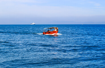 Obraz premium Small tourist ship with passengers. Beautiful seascape with a tourist boat. The ferry just left the pier.