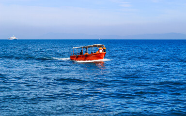 Small tourist boat with passengers. Beautiful seascape with a tourist boat.
