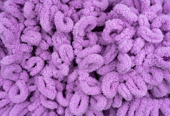 Soft yarn, delicate purple yarn. Hand knitting as a hobby. Texture or background