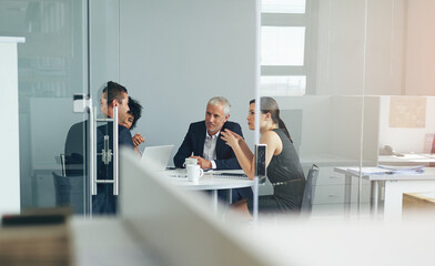 Planning their next venture. Shot of a group of businesspeople having a meeting together in an...
