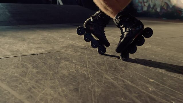Extreme roller skater riding outdoors. Man feet in roller blades at park. 