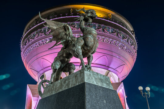 Kazan, Russia - 08.04.2020:  Kazan Wedding Palace at night with illumination, Tatarstan. Statue of Dragon Zilant, symbol of Kazan city close-up. urban landmark.