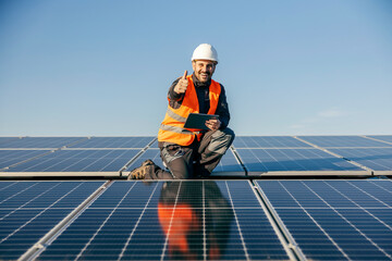 A handyman on roof surrounded by solar panels giving thumbs up for eco living.