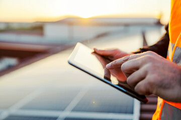 Fototapeta Close up of hand scrolling on tablet and checking on solar panels. obraz