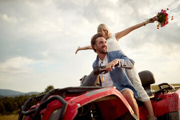 Happy bride and groom enjoying a quad atv vehicle at nature