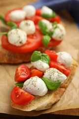 Delicious sandwiches with mozzarella, fresh tomatoes and basil on parchment