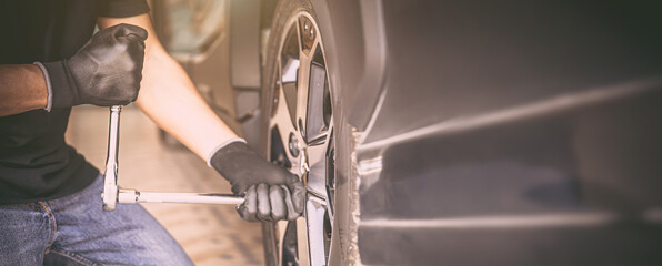Auto mechanic checking air pressure and inflating car tires. Concept of car care service and maintenance.