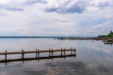 Obraz premium A jetty at the Steinhuder Meer with some boats in the background, seen in Steinhude, Lower Saxony, Germany