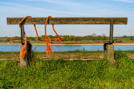 A bench with a view towards the River Rhine on the dyke in Orsoy, North Rhine-Westphalia, Germany