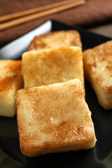 Delicious turnip cake on ceramic black plate, closeup