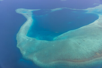 Tropical islands and atolls in Maldives from aerial view. Famous travel destination and luxury vacation or summer holiday concept. Aerial landscape of blue sea and resorts, hotels. Gorgeous nature