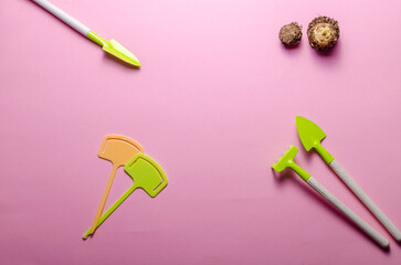 green garden tools on pink background