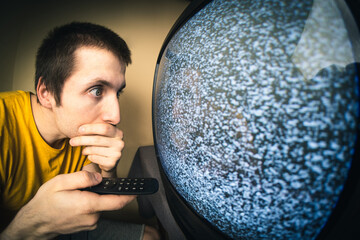 Man watching TV with remote control