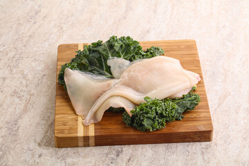 Raw squid over wooden board