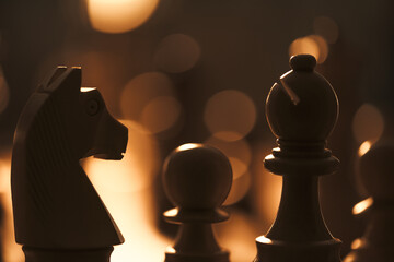 Wooden chess pieces on the chessboard and dim light