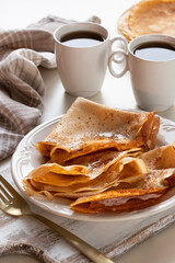 Homemade pancakes with honey and tea on a light background
