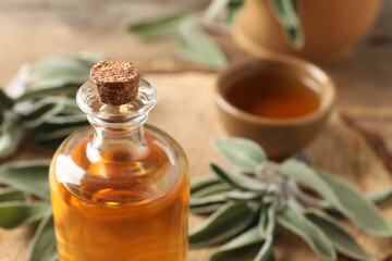 Bottle of essential sage oil on table, closeup. Space for text