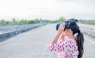 Girl on steel bridge using VR headset, living in completely different place with the help of using...